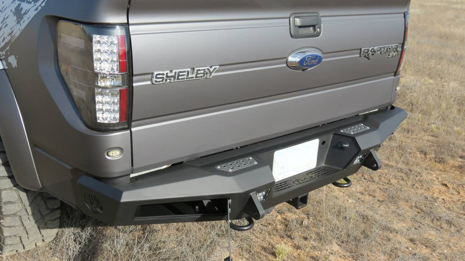 2010 - 2014 Ford Raptor 2009 - 2014 Ford F-150 2011 - 2014 Ford Ecoboost F-150 HoneyBadger Rear Bumper with Integrated Storage Box and Backup Sensor cutouts with Dually mounts in Hammer Black with Satin Black panels. product image