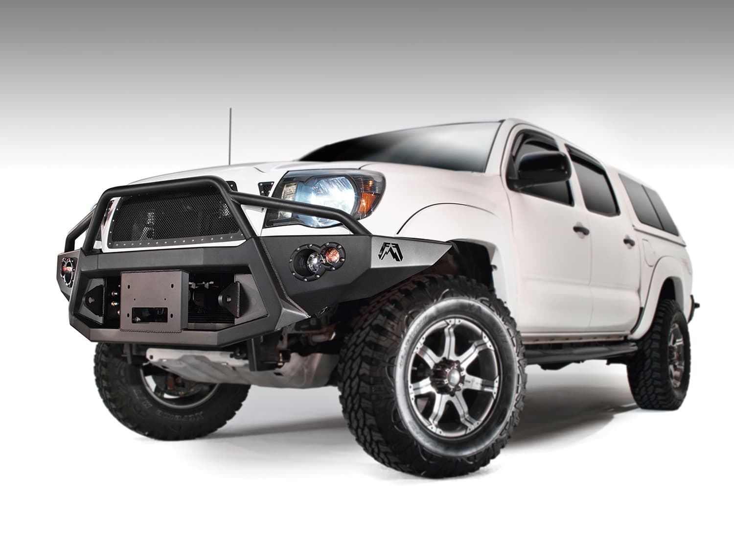 Fab Fours Premium Heavy Duty Winch Front Bumper; 2 Stage Black Powder Coated; w/Pre-Runner Grill Guard; Incl. 1in. D-Ring Mts./Light Cut-Outs w/Hella 90mm Fog Lamps/60mm Turn Signals;